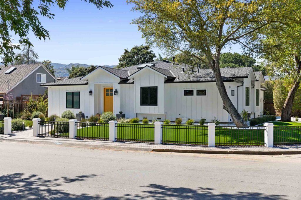 Mature trees in front yard of modern white farmhouse showing tree placement and property landscape