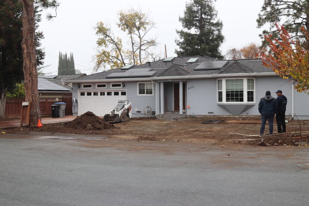 Residential property with large tree trunk and debris pile indicating work in progress